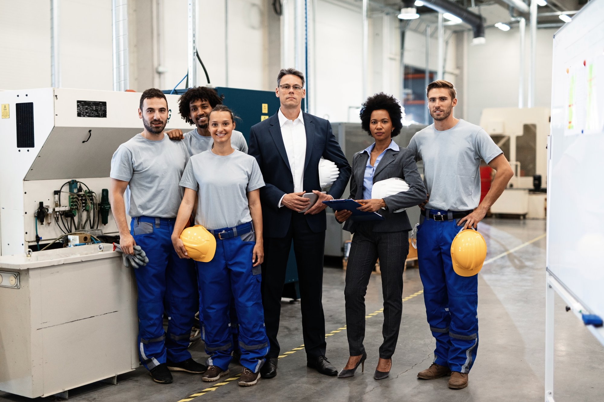 portrait-group-engineers-corporate-managers-standing-factory-looking-camera